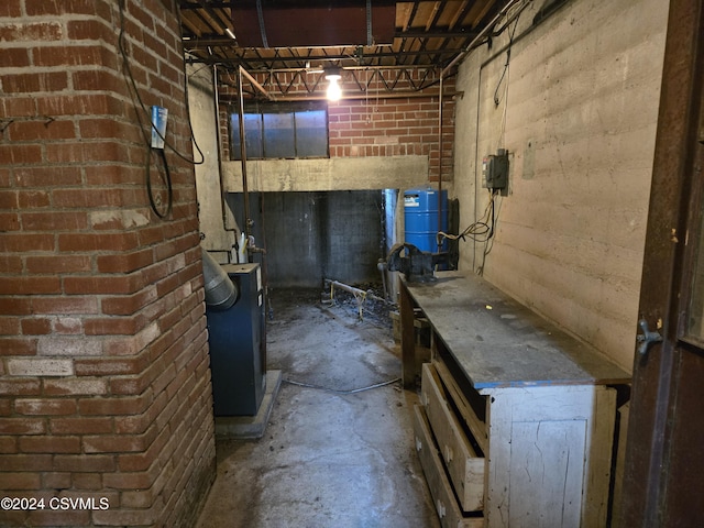 unfinished below grade area with a heating unit and brick wall