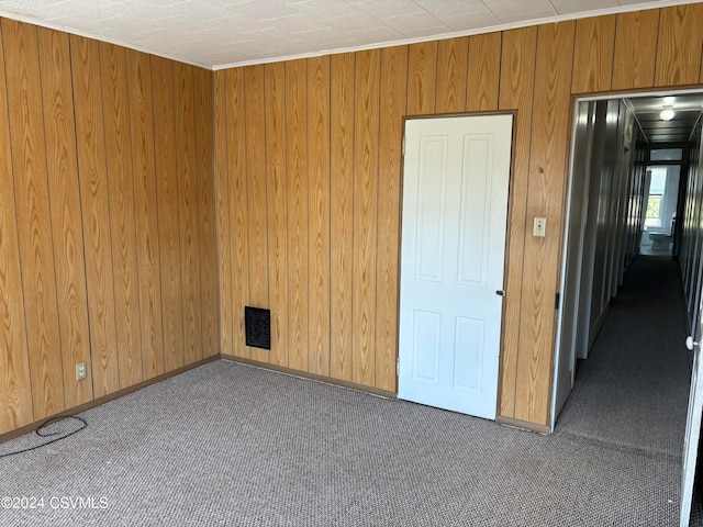 empty room with wooden walls and carpet