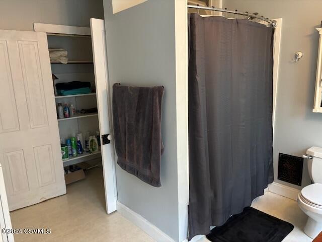 bathroom featuring toilet and a shower with shower curtain