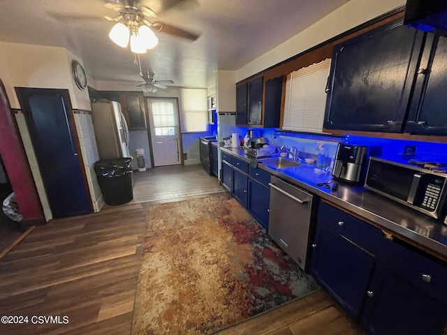 kitchen featuring blue cabinets, ceiling fan, sink, dark wood-type flooring, and stainless steel appliances