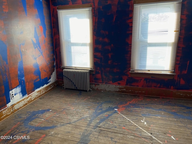 spare room with radiator and hardwood / wood-style floors