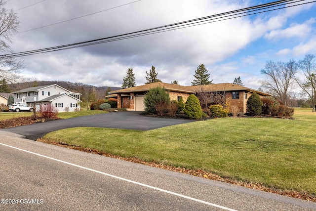 ranch-style house featuring a garage and a front lawn