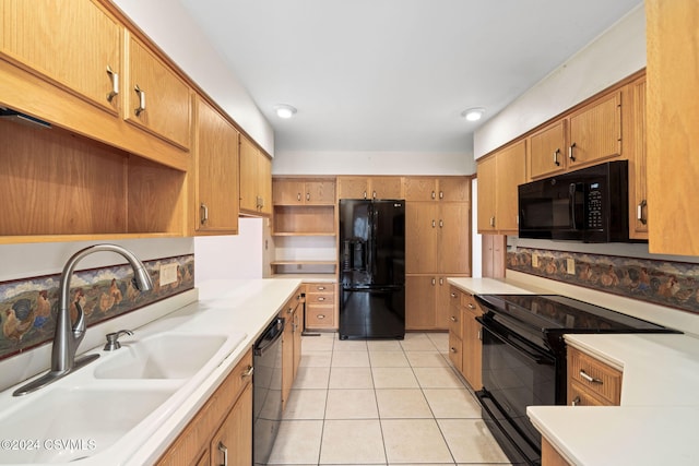 kitchen featuring black appliances, light tile patterned floors, and sink