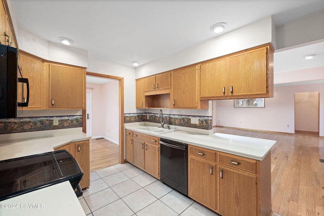 kitchen featuring dishwasher, range, light wood-type flooring, and sink