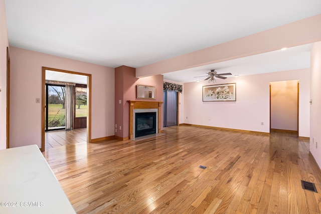 unfurnished living room featuring hardwood / wood-style flooring and ceiling fan