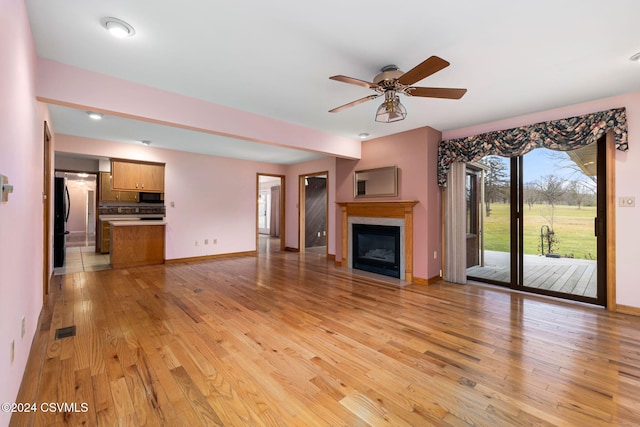 unfurnished living room featuring ceiling fan and light hardwood / wood-style floors