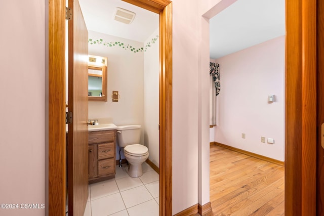 bathroom with vanity, hardwood / wood-style flooring, and toilet