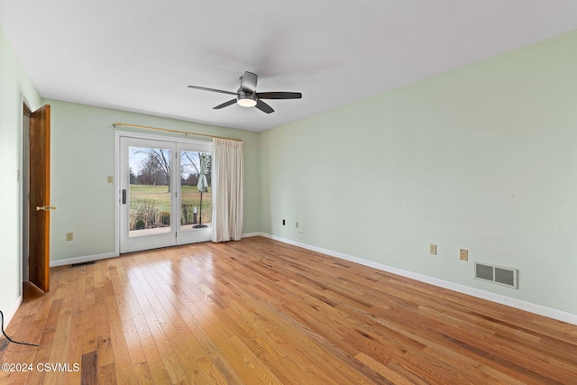 empty room with ceiling fan and light hardwood / wood-style flooring