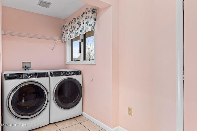 laundry area with light tile patterned flooring and washing machine and clothes dryer