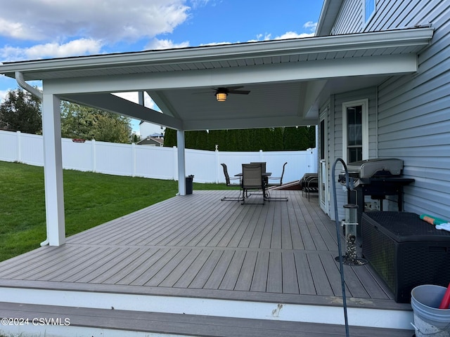 wooden deck featuring ceiling fan and a yard