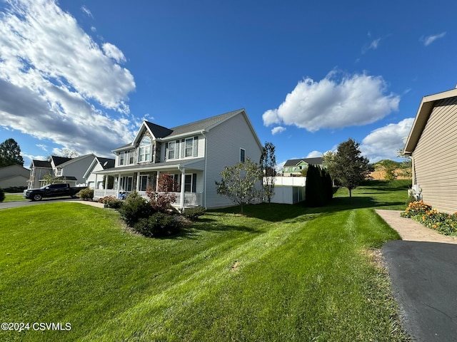 view of side of home with a porch and a lawn