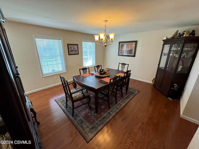 dining area featuring dark hardwood / wood-style floors and an inviting chandelier