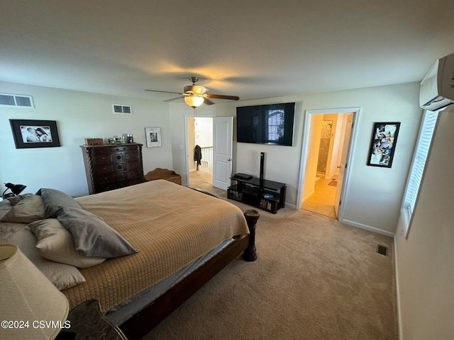 bedroom with ensuite bath, light carpet, a wall unit AC, and ceiling fan