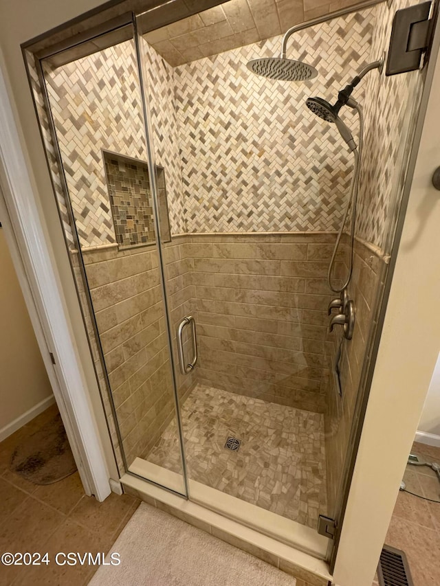 bathroom with tile patterned flooring and walk in shower