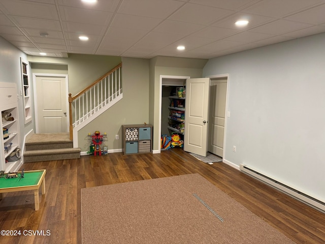 interior space featuring a baseboard radiator, a drop ceiling, and dark hardwood / wood-style floors