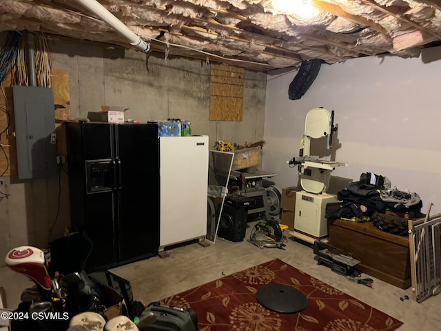 basement featuring electric panel and black refrigerator with ice dispenser