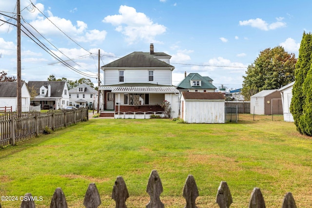 back of property with a lawn and a storage unit