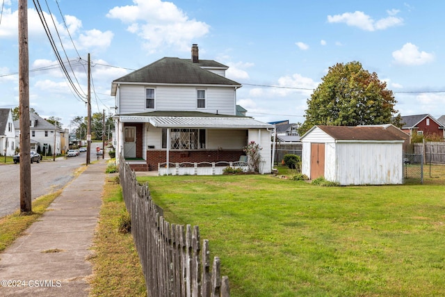 view of front of property featuring a storage unit, a front lawn, and covered porch