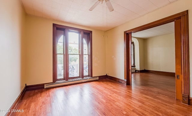 unfurnished room featuring ceiling fan, hardwood / wood-style flooring, ornamental molding, and a baseboard radiator