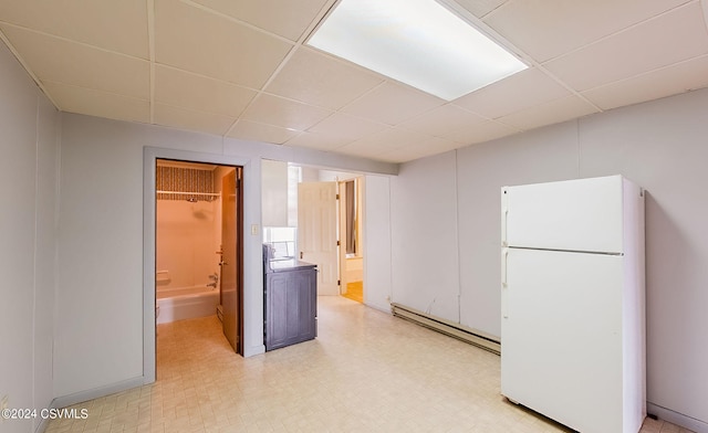 interior space featuring a baseboard radiator, white fridge, and a paneled ceiling