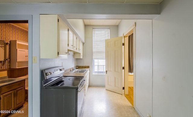 kitchen featuring a wealth of natural light, sink, and stainless steel range with electric stovetop