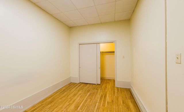 unfurnished bedroom with light hardwood / wood-style floors and a drop ceiling