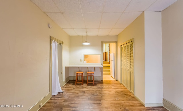 corridor featuring a paneled ceiling and hardwood / wood-style floors