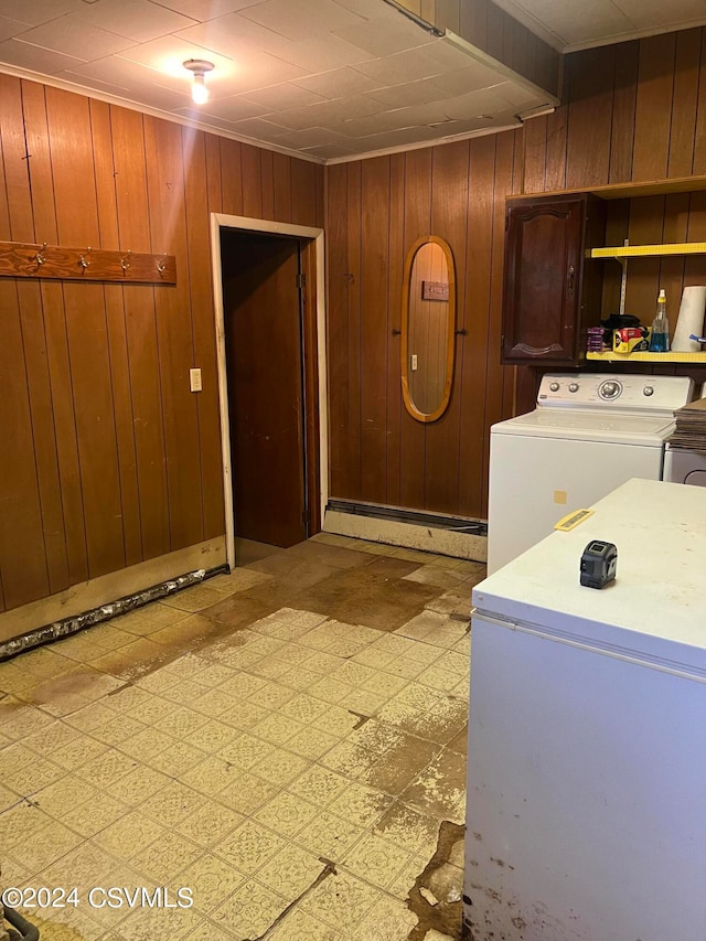 clothes washing area featuring wooden walls and washer and dryer