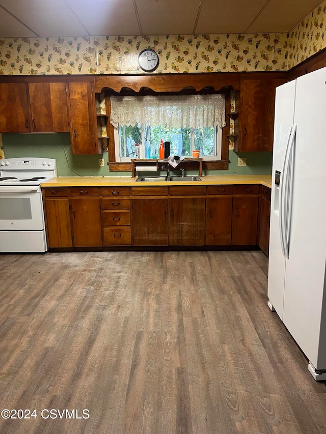 kitchen featuring sink, hardwood / wood-style flooring, and white appliances