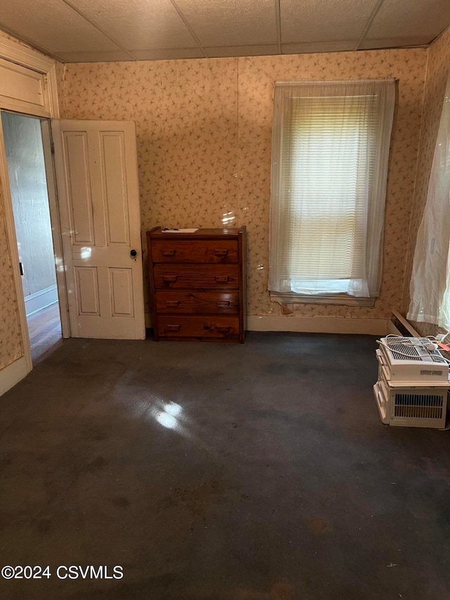 unfurnished bedroom featuring a drop ceiling