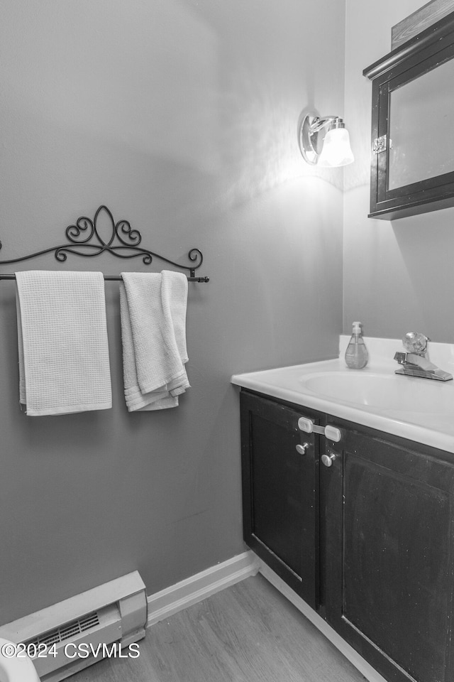 bathroom featuring vanity, wood-type flooring, and a baseboard radiator