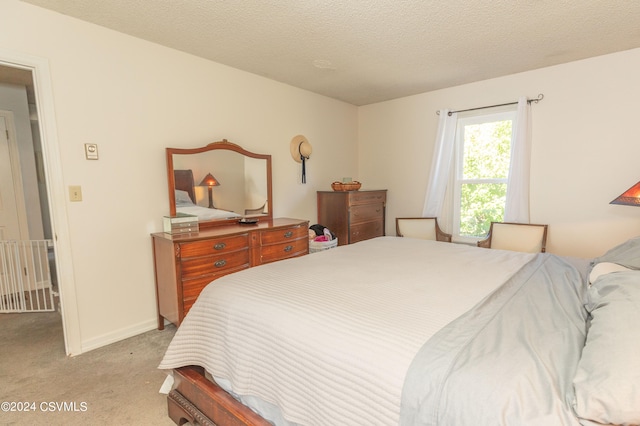 bedroom with light carpet and a textured ceiling