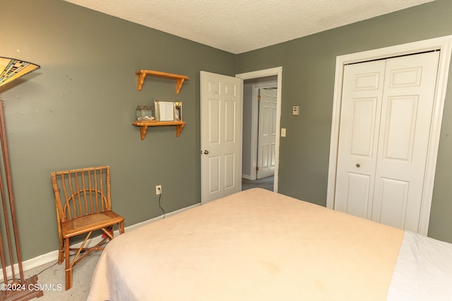 carpeted bedroom with a closet and a textured ceiling