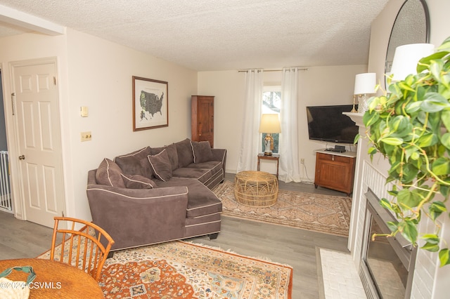 living room featuring a textured ceiling and light wood-type flooring