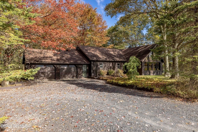 view of front of property featuring an attached garage and gravel driveway