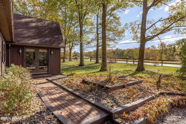 view of yard featuring french doors and a vegetable garden