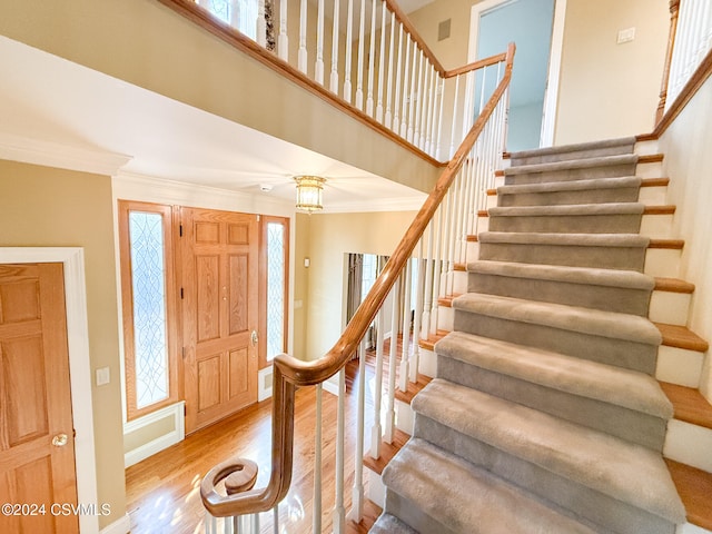 foyer entrance featuring a wealth of natural light, light hardwood / wood-style flooring, and crown molding