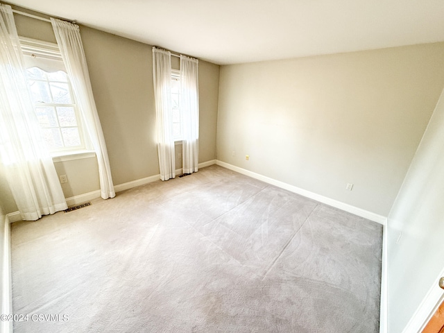 empty room with a wealth of natural light and light carpet