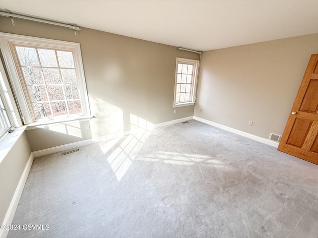 carpeted spare room with plenty of natural light