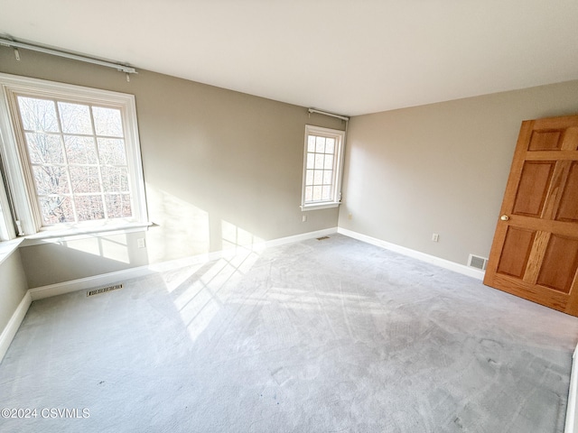 unfurnished room with a wealth of natural light and light carpet