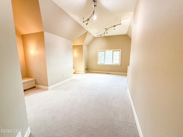 additional living space with vaulted ceiling and light carpet