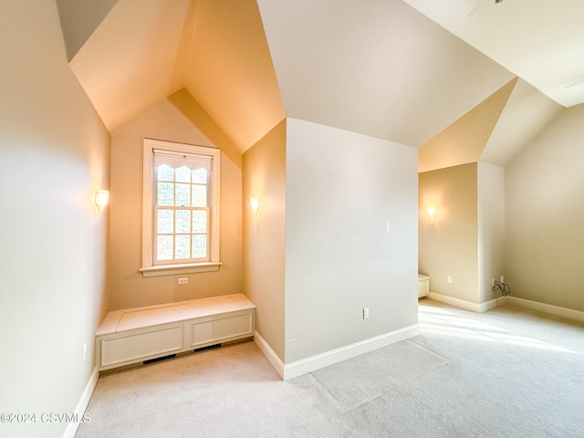 bonus room with lofted ceiling and light carpet