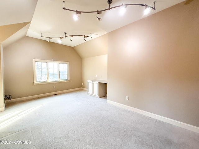 additional living space with lofted ceiling and light carpet