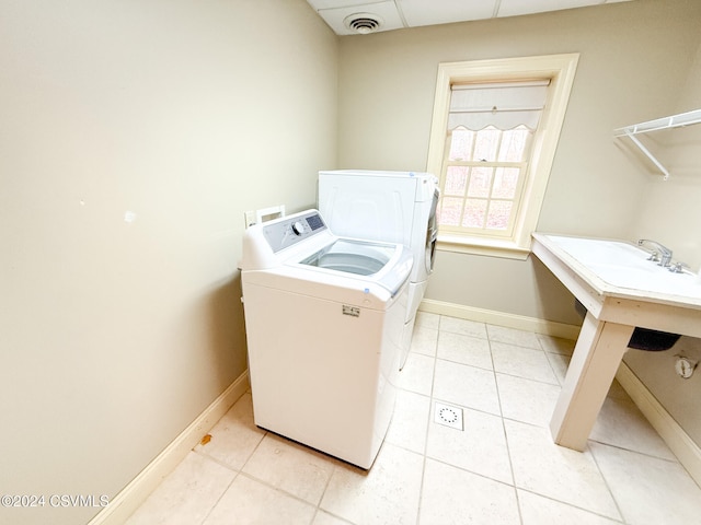 laundry room with washer and clothes dryer and light tile patterned flooring