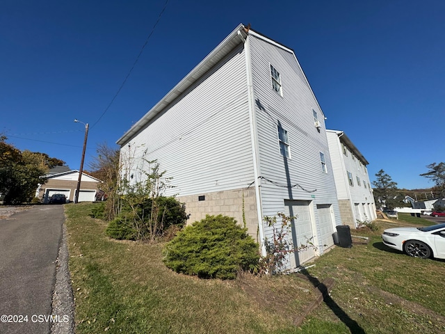 view of property exterior with a yard and a garage