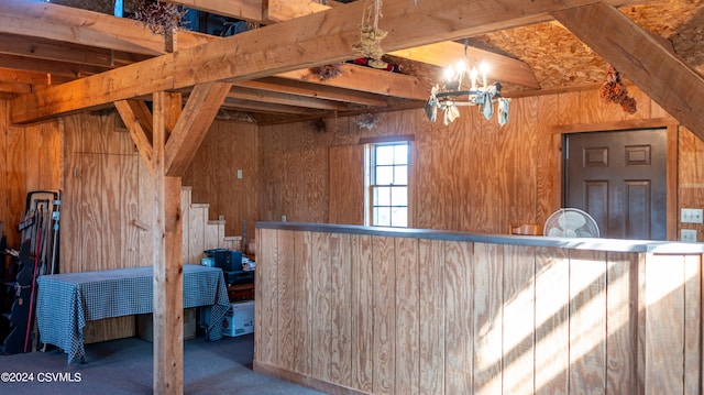 interior space with pendant lighting, wood walls, beamed ceiling, carpet floors, and an inviting chandelier