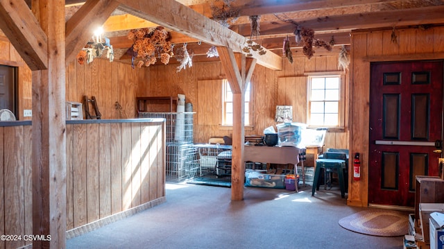 interior space with beam ceiling and wooden walls