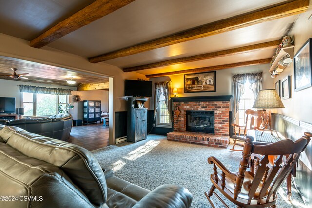 living room featuring a brick fireplace and beam ceiling