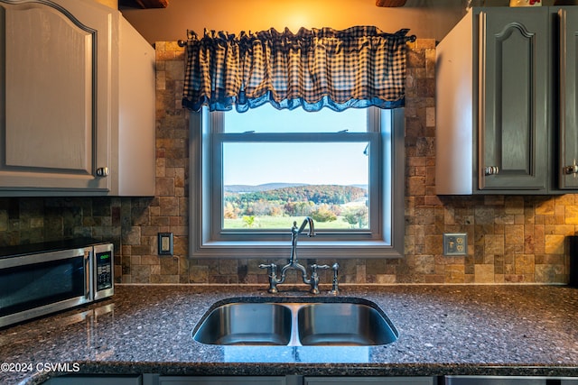 kitchen with sink, decorative backsplash, and dark stone countertops