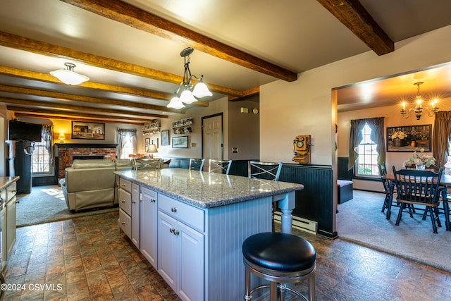 kitchen featuring a kitchen island, pendant lighting, a breakfast bar area, and white cabinets